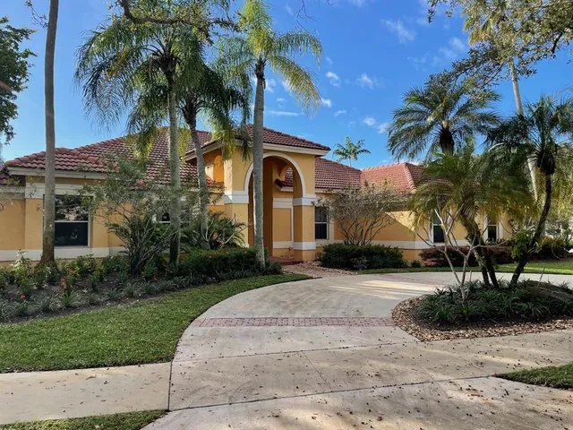 a front view of a house with a yard and potted plants