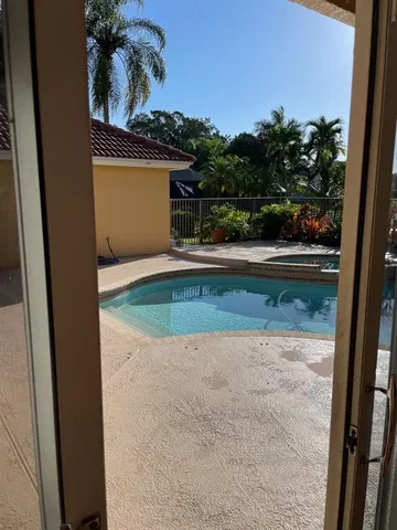 a view of a swimming pool with a patio and a yard