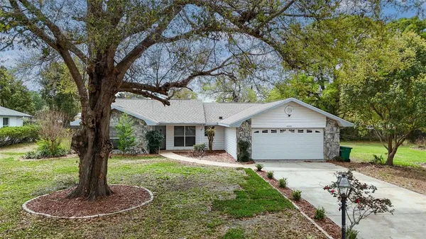 a front view of a house with a yard and trees