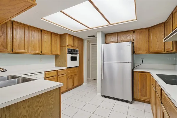 a kitchen with a refrigerator a stove top oven a sink and cabinets
