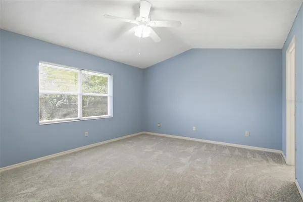 an empty room with a window and a fan