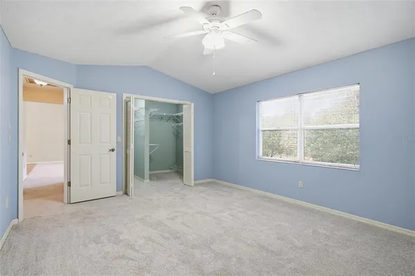 an empty room with fan and windows