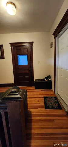 a view of staircase with wooden floor and white walls