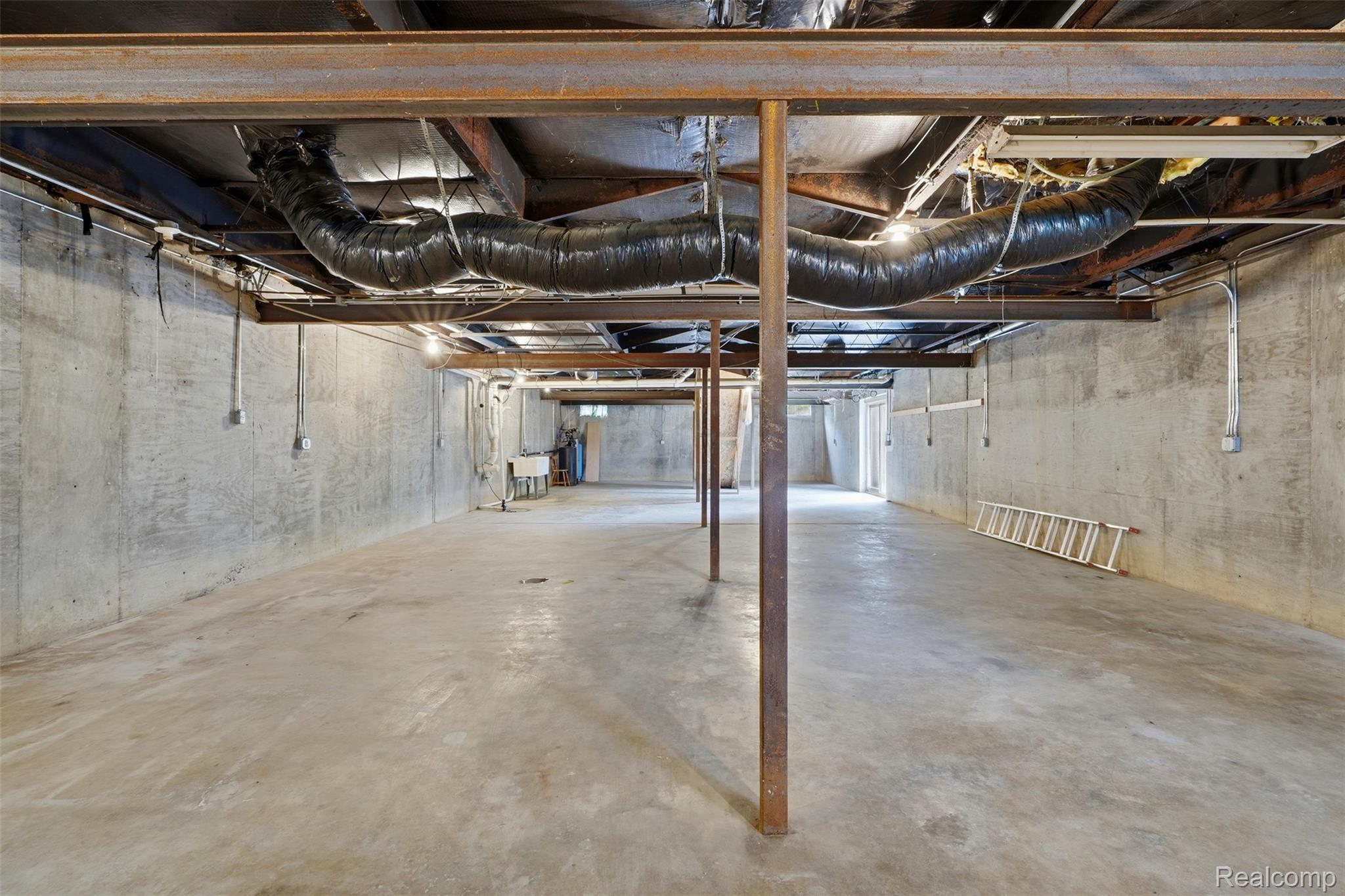 4420 Dublin Road Burton, MI 48529 - Photo 32 of 56 Expansive unfinished basement featuring concrete flooring, concrete walls, exposed ceiling joists, exposed ductwork, and steel support beams
