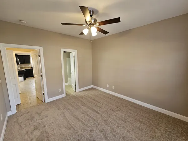 an empty room with closet and a ceiling fan