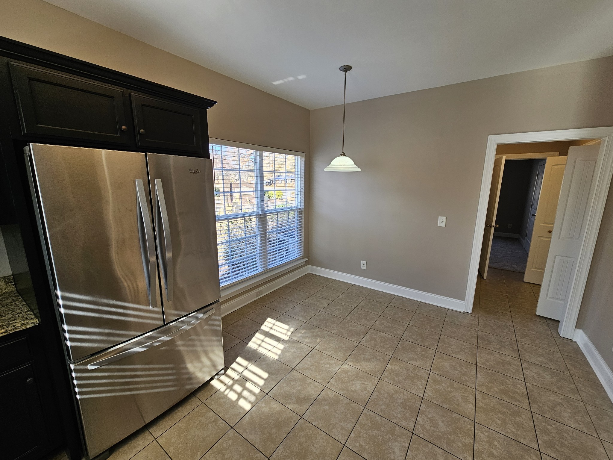 322 Rowlette Circle Murfreesboro, TN 37127 - Photo 4 of 23 a view of a refrigerator in kitchen and an empty room with wooden floor