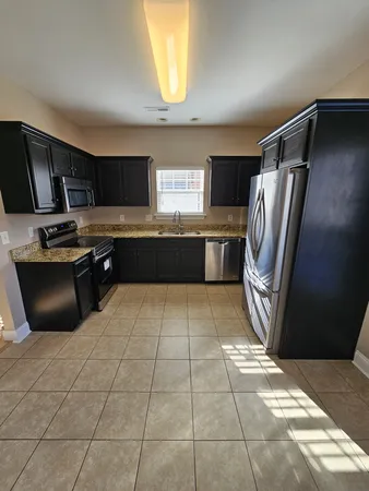 a kitchen with stainless steel appliances granite countertop a refrigerator and a stove top oven