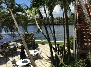 a vase of flowers sitting on a table in front of a house