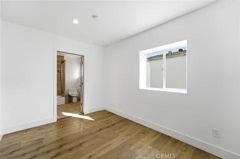 an empty room with wooden floor and a window