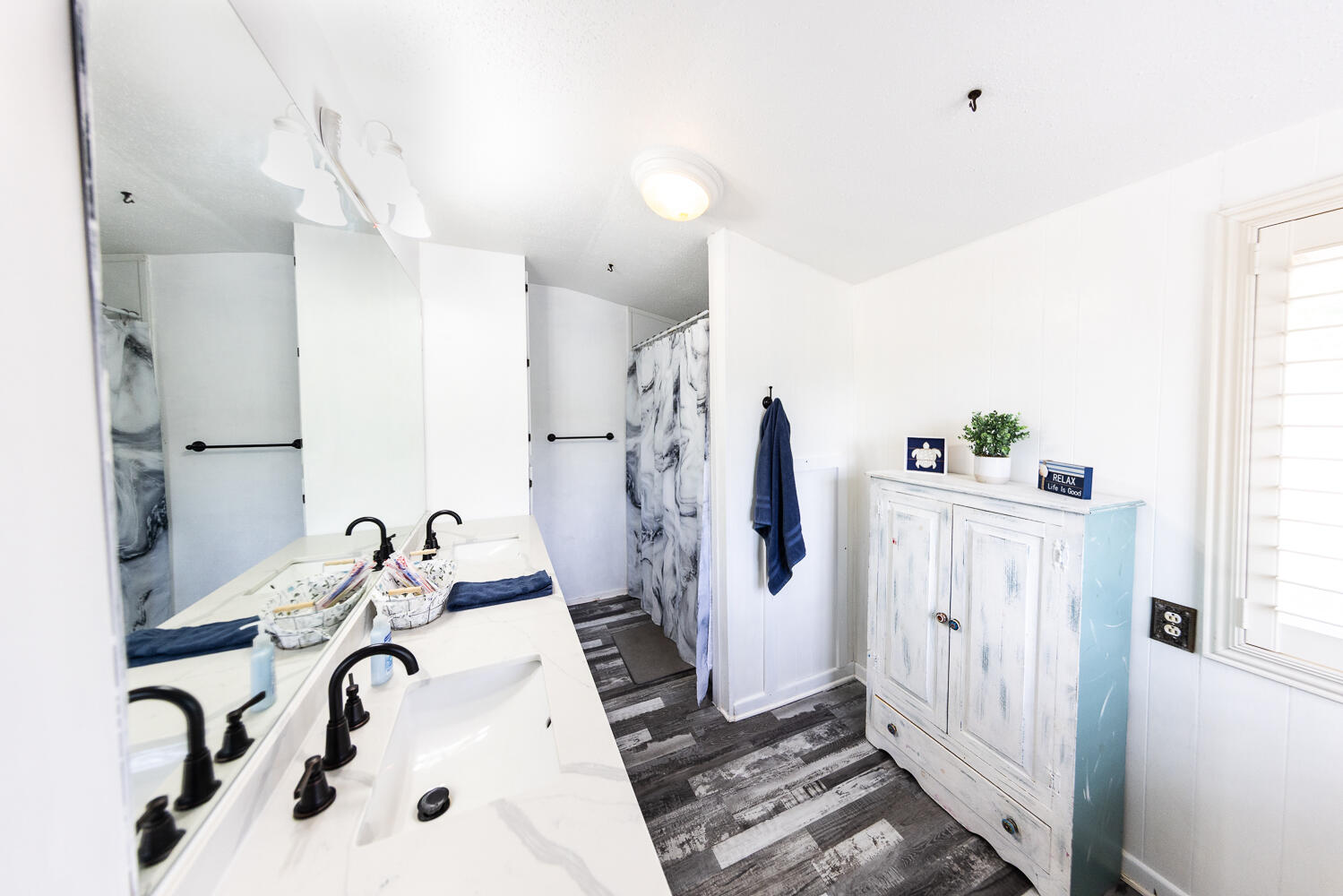 585 Comanche Drive Lubbock, TX 79404 - Photo 11 of 17 a bathroom with a sink a mirror and a shower