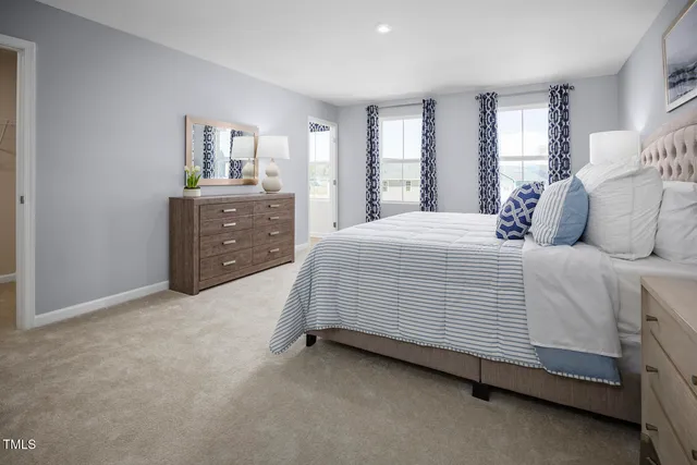 a spacious bedroom with a bed table and window