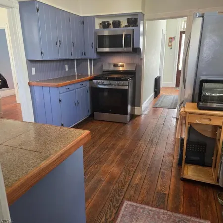 a kitchen with wooden floors and stainless steel appliances