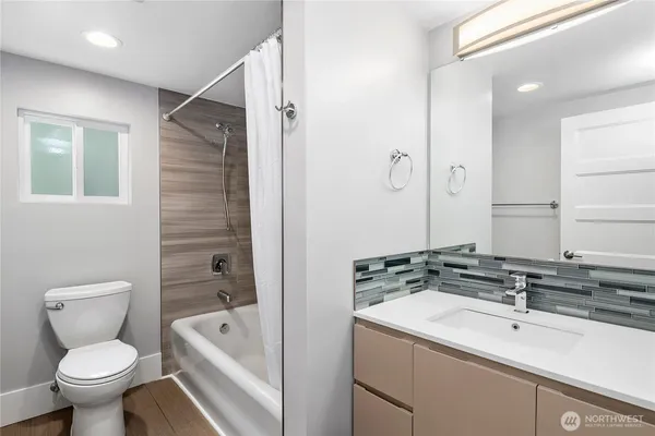 a bathroom with a sink toilet vanity and shower