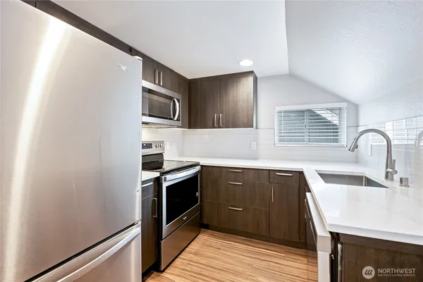 a kitchen with stainless steel appliances granite countertop a sink stove and refrigerator