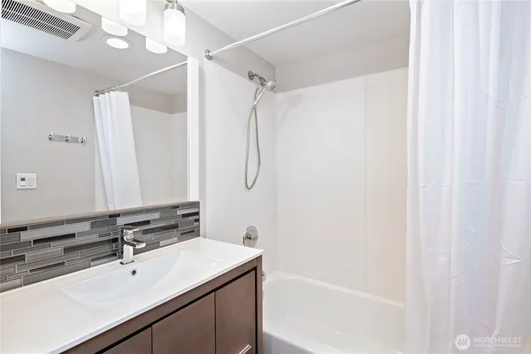 a bathroom with a sink a mirror and a bathtub