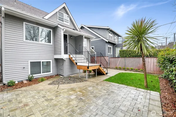 a view of a house with backyard and a tree