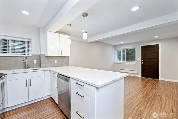 a kitchen with a wooden floor and window