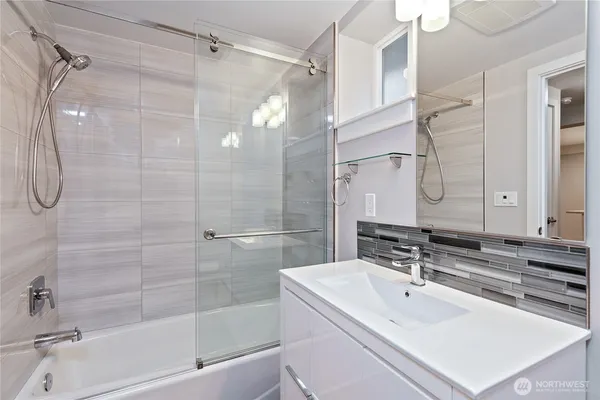a bathroom with a sink double vanity mirror and a bathtub