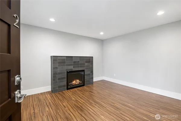 a view of empty room with wooden floor and fireplace