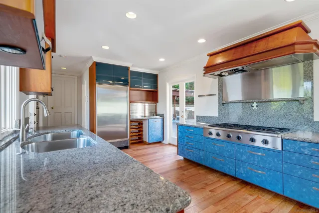 a kitchen with stainless steel appliances granite countertop a sink stove and refrigerator