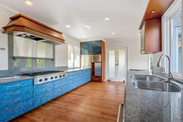 a kitchen with stainless steel appliances granite countertop a sink and a stove