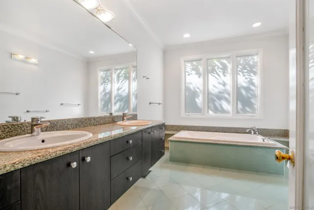 a spacious bathroom with a double vanity sink bathtub and next to a window