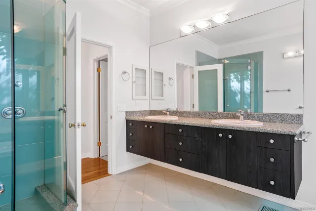 a spacious bathroom with a granite countertop sink mirror and shower