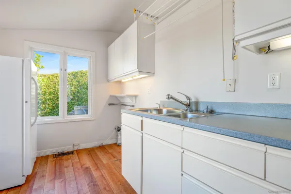 a kitchen with a sink wooden floor and a window