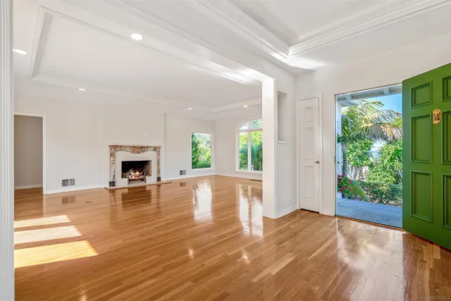 a view of empty room with wooden floor and fireplace