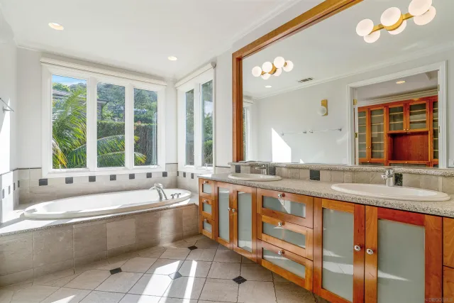 a bathroom with a granite countertop tub sink and mirror