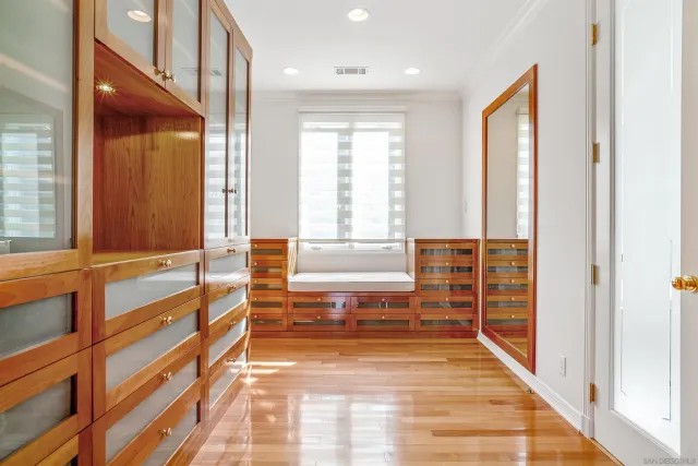 a view of a hallway with wooden floor and windows
