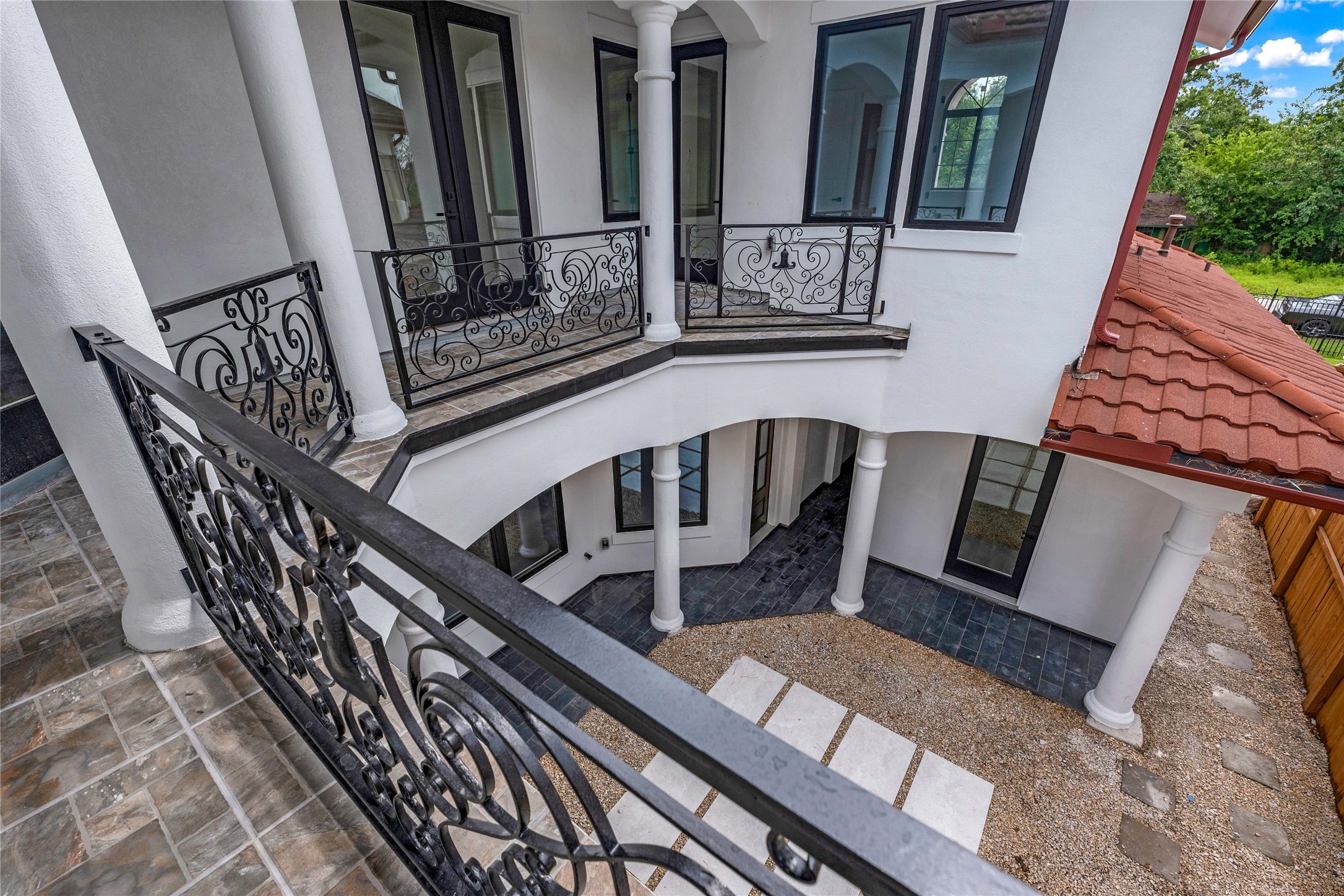 2031 Peppermill Road Houston, TX 77080 - Photo 37 of 48 The second floor balcony overlooks the serene courtyard. The far right door on the first floor leads to the casita/guest suite, thoughtfully separated from the main home by the corridor.