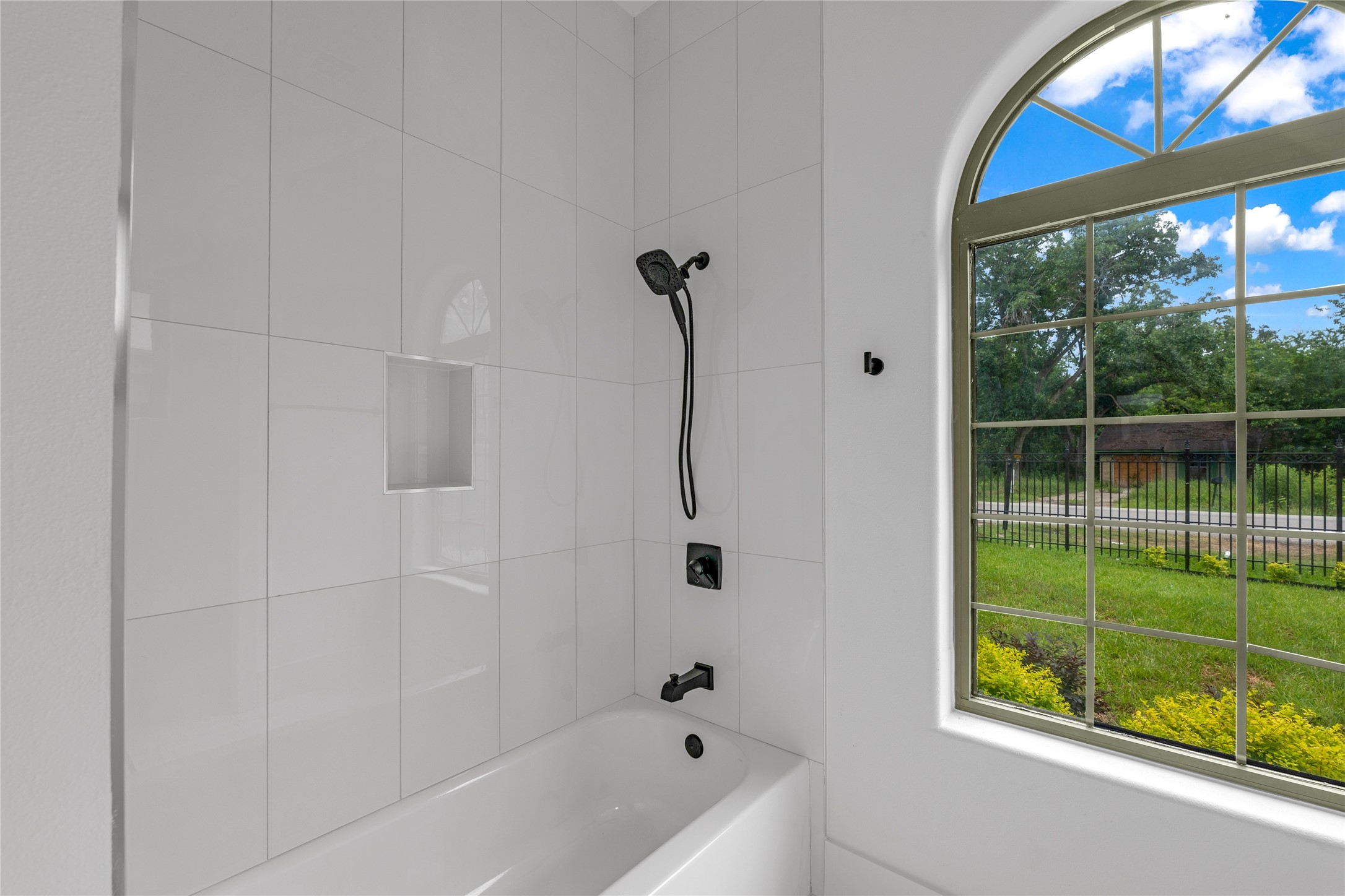 2031 Peppermill Road Houston, TX 77080 - Photo 42 of 48 Bathroom 4 showcases arched windows and a tub/shower combo with handheld shower