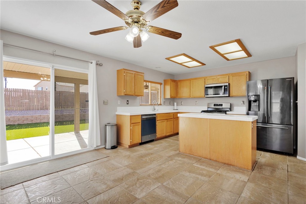 11979 Luna Road Victorville, CA 92392 - Photo 11 of 49 a large kitchen with a large window and stainless steel appliances