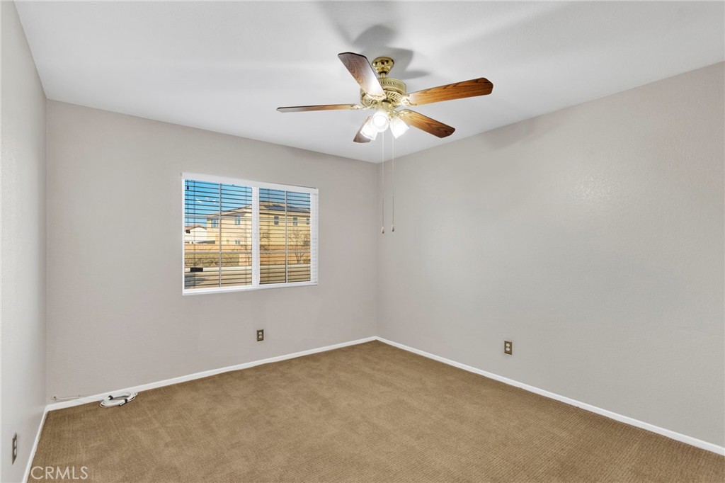 11979 Luna Road Victorville, CA 92392 - Photo 20 of 49 an empty room with windows and fan
