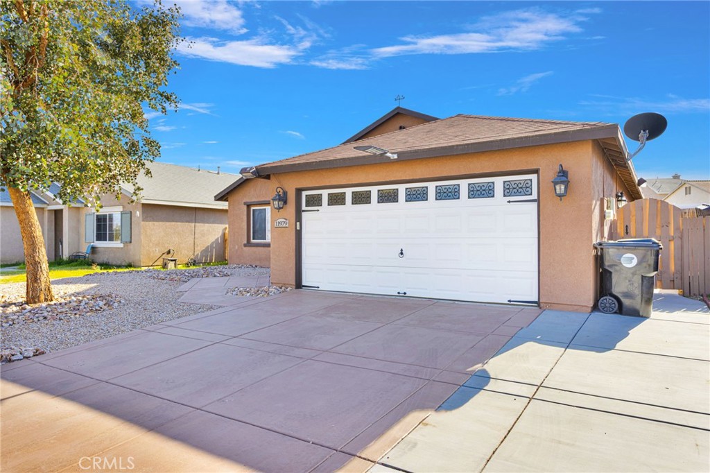 11979 Luna Road Victorville, CA 92392 - Photo 2 of 49 a front view of a house with a yard and garage