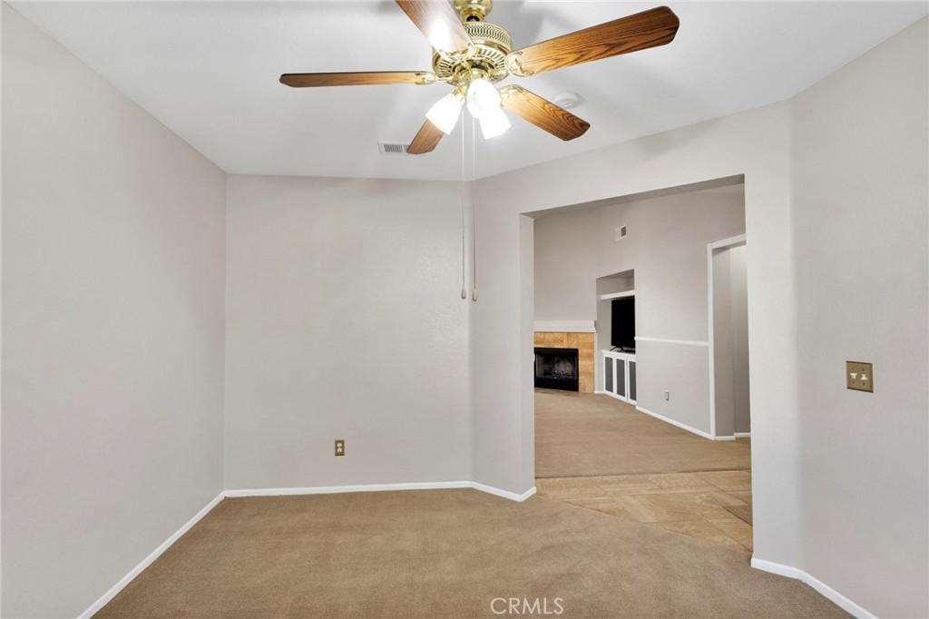 11979 Luna Road Victorville, CA 92392 - Photo 21 of 49 an empty room with chandelier fan and kitchen view