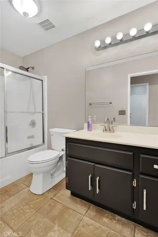 an empty room with windows and chandelier fan