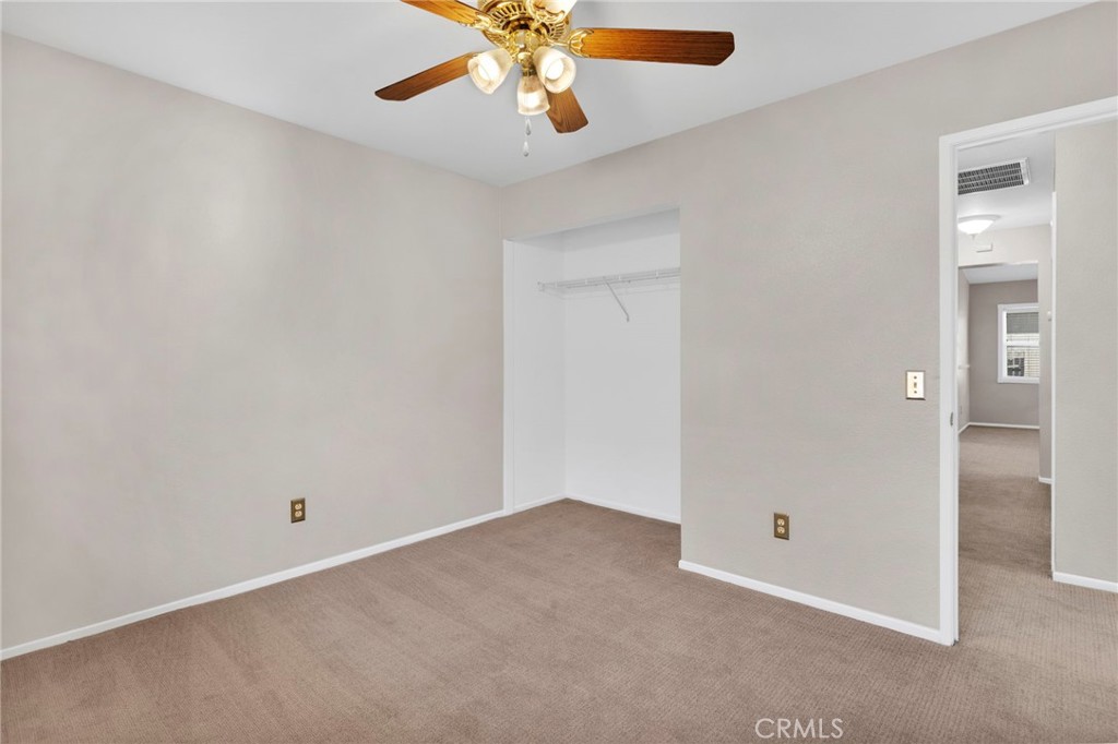 11979 Luna Road Victorville, CA 92392 - Photo 28 of 49 an empty room with a chandelier fan and wooden floor