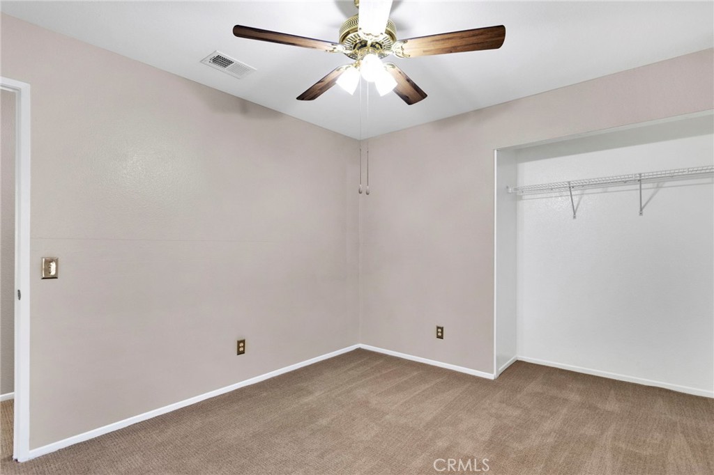 11979 Luna Road Victorville, CA 92392 - Photo 30 of 49 an empty room with closet and a chandelier fan