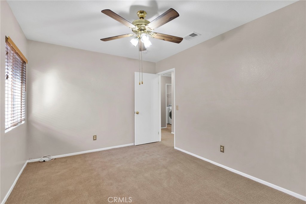 11979 Luna Road Victorville, CA 92392 - Photo 31 of 49 an empty room with a chandelier fan and windows