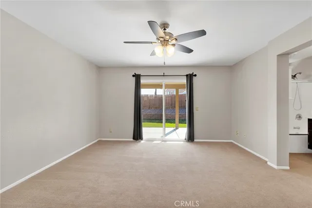 a view of an empty room with a ceiling fan