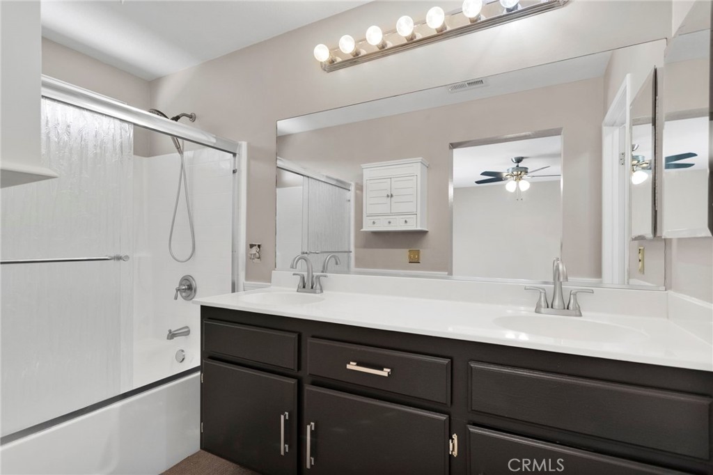 11979 Luna Road Victorville, CA 92392 - Photo 37 of 49 a bathroom with a double vanity sink a mirror and shower