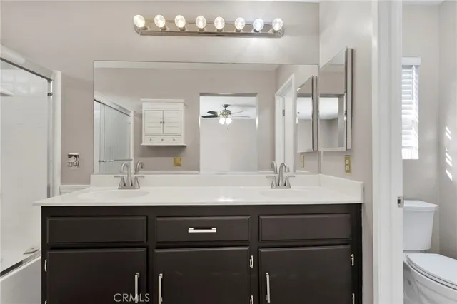 a bathroom with a double vanity sink toilet and mirror
