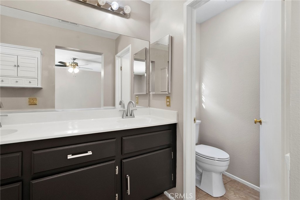11979 Luna Road Victorville, CA 92392 - Photo 40 of 49 a bathroom with a double vanity sink toilet and mirror