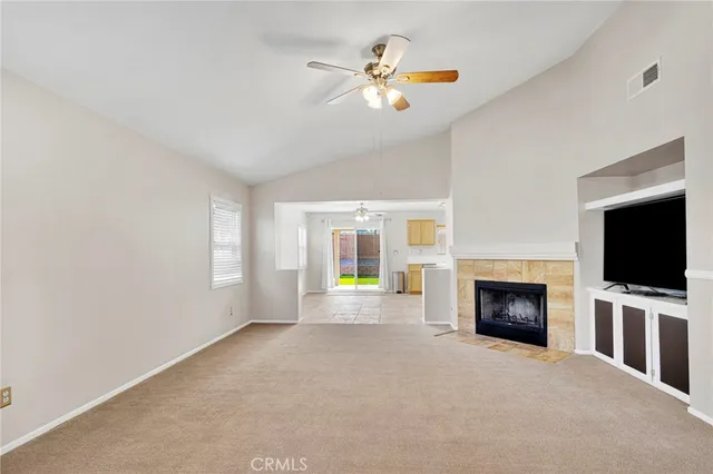 a view of an empty room with a window and fireplace