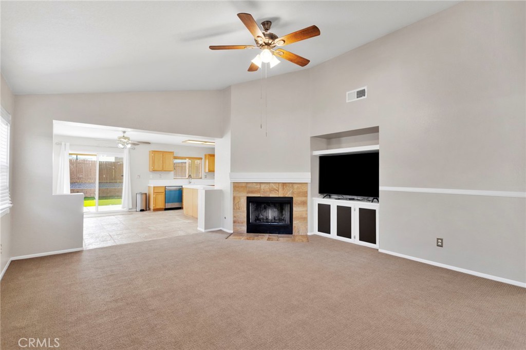 11979 Luna Road Victorville, CA 92392 - Photo 7 of 49 a view of a livingroom with a fireplace a ceiling fan and windows