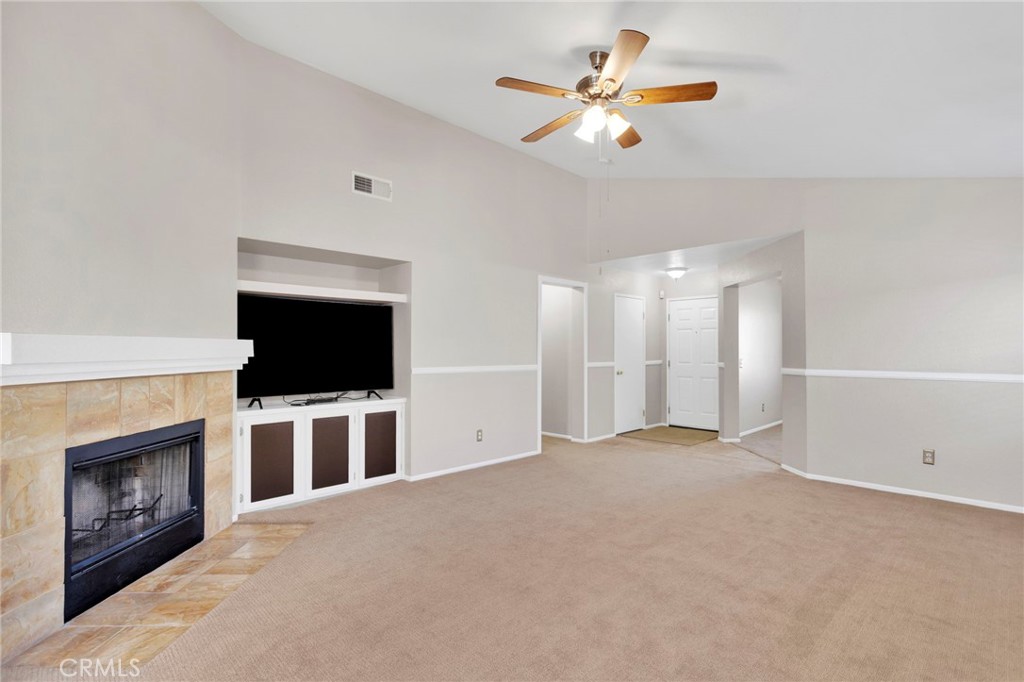 11979 Luna Road Victorville, CA 92392 - Photo 9 of 49 a view of a livingroom with a fireplace a ceiling fan and a window
