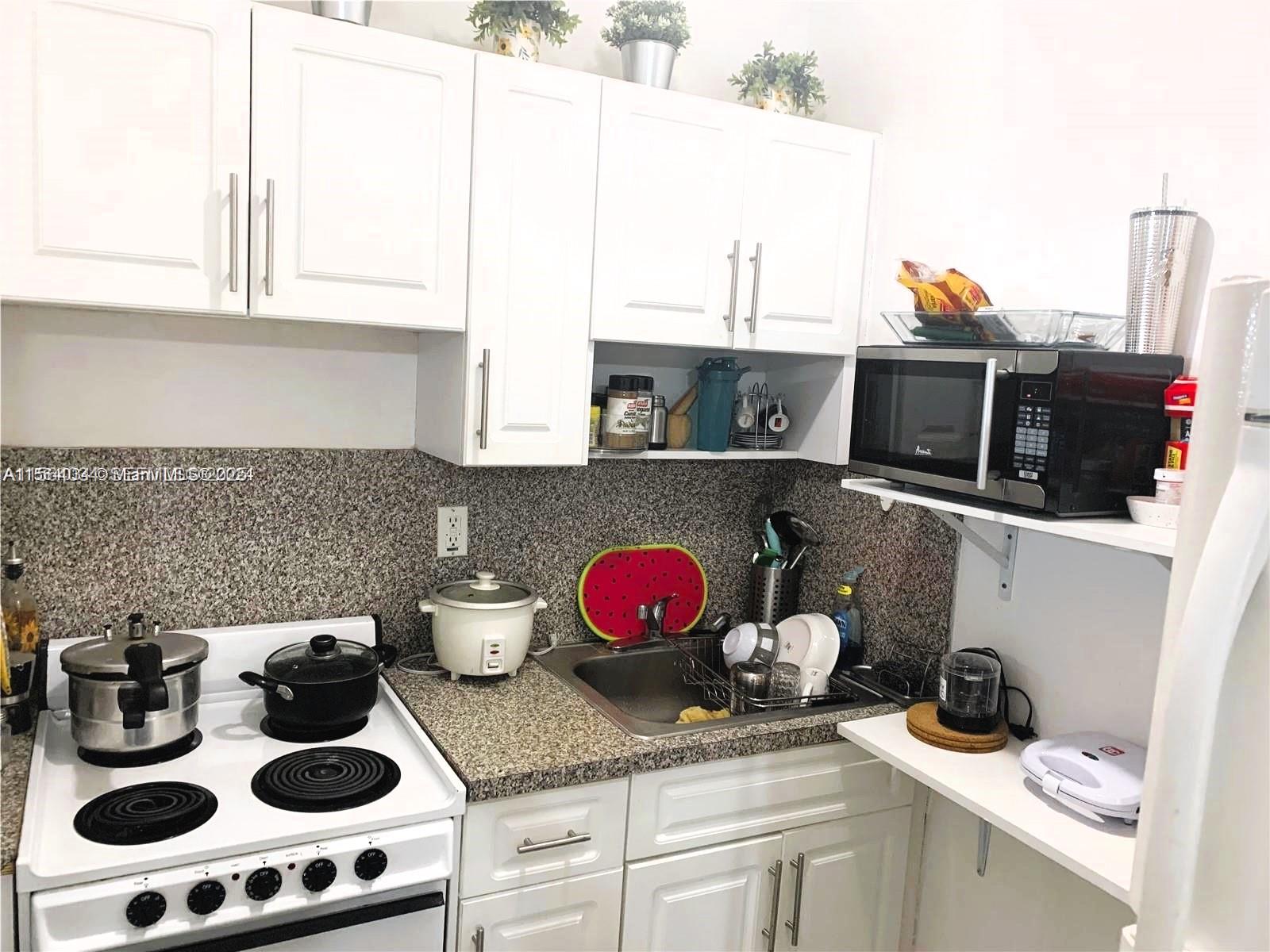 662 East 21st Street Hialeah, FL 33013 - Photo 12 of 21 a kitchen with a stove and a microwave