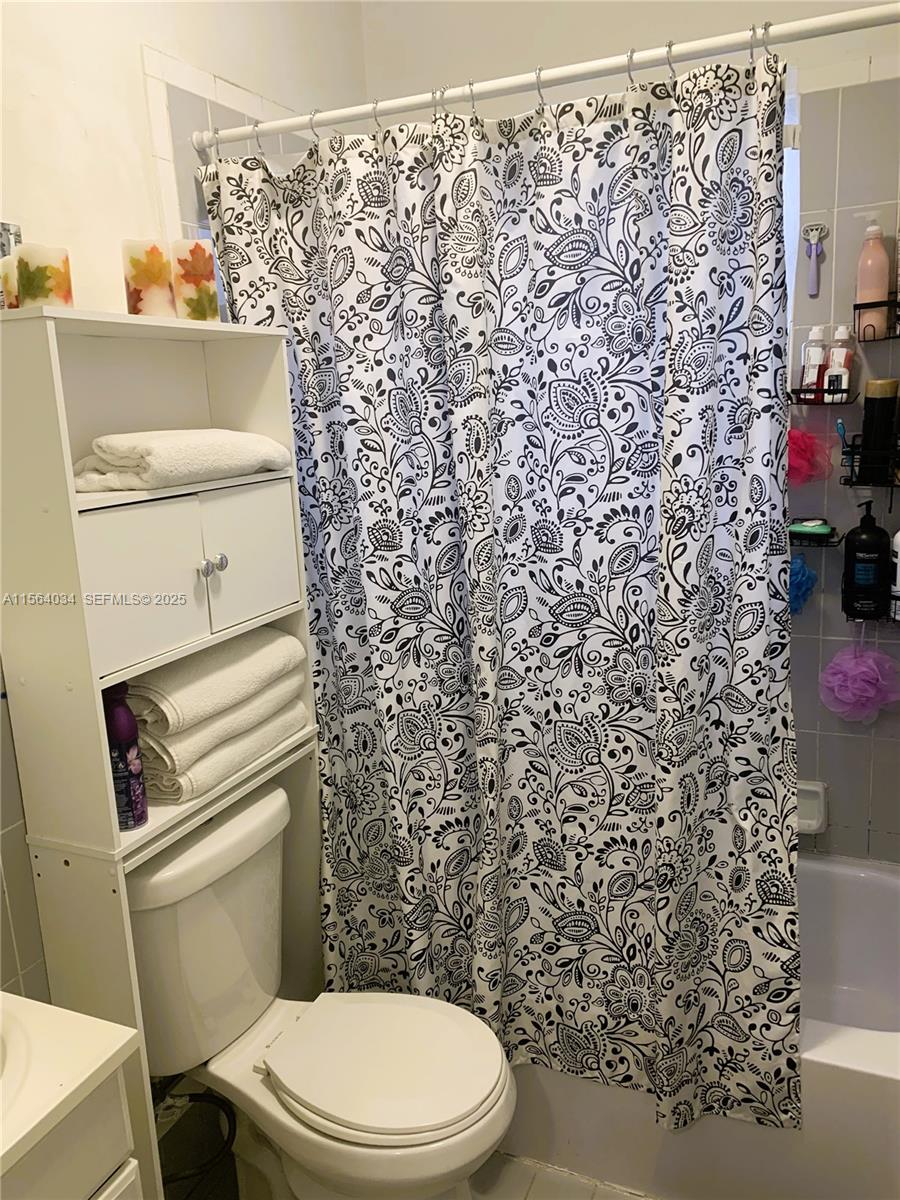 662 East 21st Street Hialeah, FL 33013 - Photo 8 of 21 a white toilet sitting next to a shower curtain